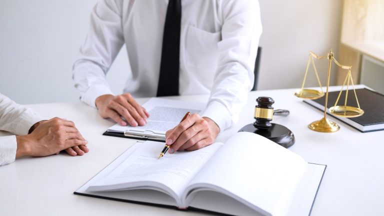 Biznesmeni lub prawnik mający spotkanie zespołu omawiające dokumenty umowy, sędzia młotek z prawnikami sprawiedliwości w kancelarii prawnej w tle, prawo, porady i koncepcja sprawiedliwości.