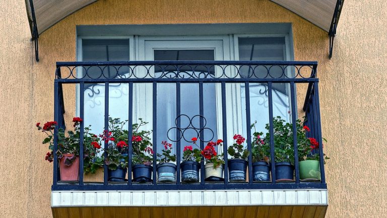 Balkon na fasadzie budynku z donicami z kwiatami