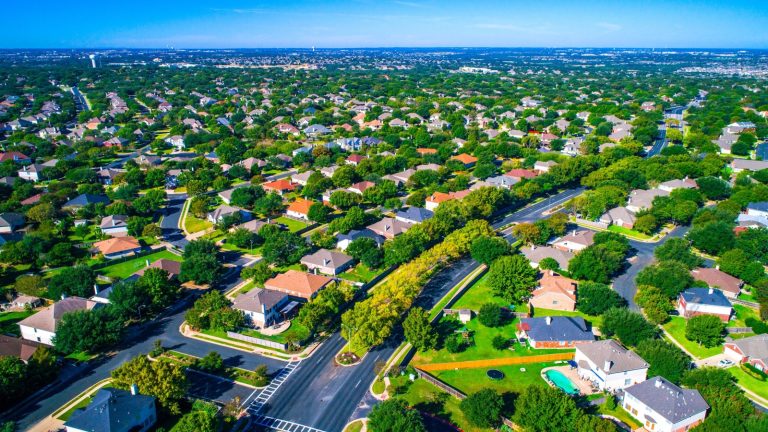 Setki domów wzdłuż zakrzywionych nowoczesnych dróg nowego przedmieścia na północ od Austin w Round Rock, Teksas, USA widok z lotu ptaka nad przedmieściem suburbia społeczność sąsiedzka